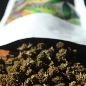 Paquet de fleurs de CBD renversé, avec petites têtes de fleurs visibles